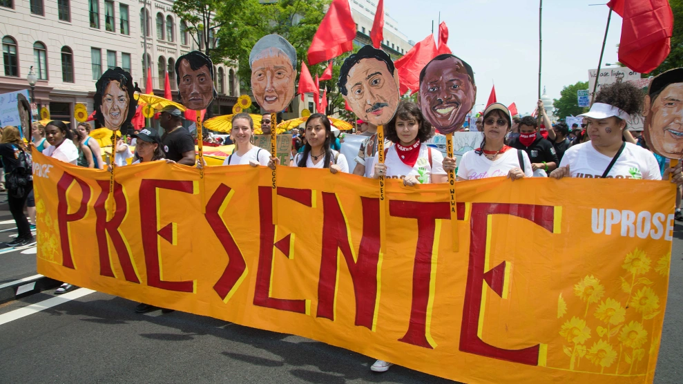 latinx climate protesters march with a banner that says "presente"